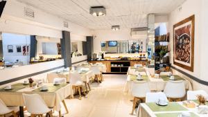 a restaurant with tables and chairs and a kitchen at Alpino Hotel in Buenos Aires