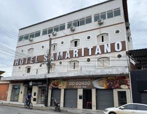 a man riding a bike in front of a building at Hotel Samaritano in Montes Claros