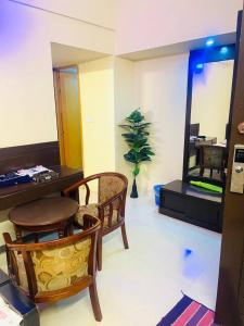 a living room with a table and chairs and a mirror at Epindi Studio Apartment in Cox's Bazar +43 photos