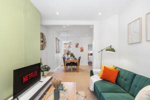 a living room with a green couch and a table at Spacious 2-Bed Eastbourne Retreat in Eastbourne