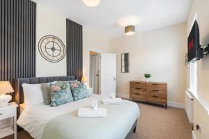 a bedroom with a bed and a dresser at Spacious 2-Bed Eastbourne Retreat in Eastbourne