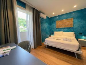 a bedroom with a bed with a blue wall at Roccaverde Hotel in Breno +56 photos