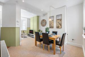 a dining room and living room with a table and chairs at Spacious 2-Bed Eastbourne Retreat in Eastbourne