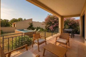 a patio with chairs and a table on a balcony at Villa familiale avec piscine hyper centre in Valras-Plage