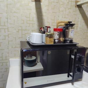 a microwave with a shelf on top of it at OrchardNest in Moinabad