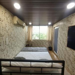a bedroom with a bed in a room with a window at OrchardNest in Moinabad