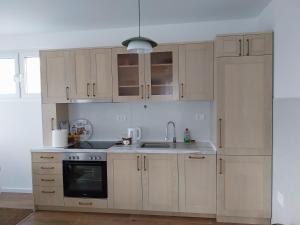 a kitchen with white cabinets and a sink at Vila Ella Mavrovo in Mavrovo
