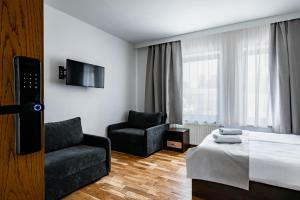 a hotel room with a bed and a chair at Restauracja Sonata in Zwierzyniec
