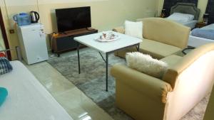 a living room with a couch and a table and a tv at SALEM House Hostel Nizwa in Nizwa