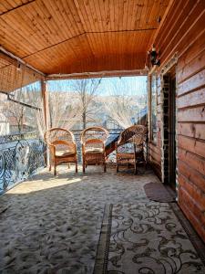 a screened in porch with four chairs on it at Карпатська Хата in Yasinya
