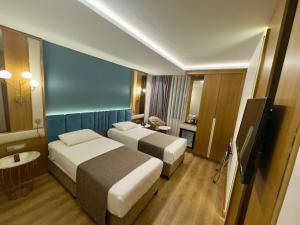 a hotel room with two beds and a television at The Parma Hotel Downtown in Istanbul