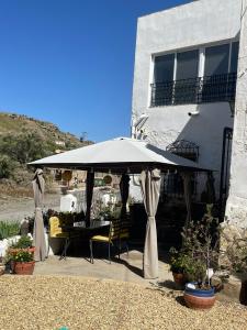 a patio with an umbrella and a table and chairs at Casa Tomas in Albox