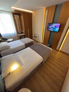 a hotel room with two beds and a flat screen tv at The Parma Hotel Downtown in Istanbul +43 photos