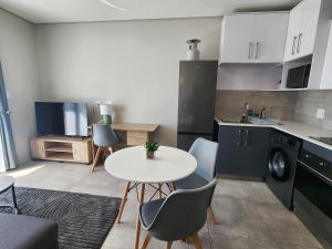 a kitchen with a table and chairs in a room at GQ Short Stays at Bellamare in Summerstrand