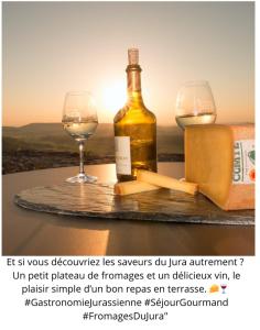 a bottle of wine and two glasses on a table at LE GITE DU LYNX in Cernon +3 photos