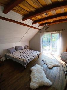 a bedroom with a bed and two rugs on the floor at Карпатська Хата in Yasinya
