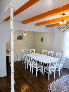 a dining room with a white table and chairs at Карпатська Хата in Yasinya