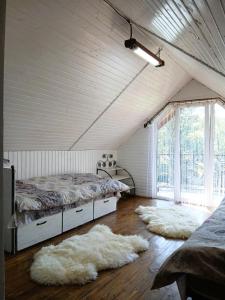 a bedroom with two beds and two rugs on the floor at Карпатська Хата in Yasinya +16 photos