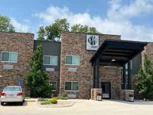 a car parked in front of a brick building at The Grove Inn and Suites in Eagle Grove
