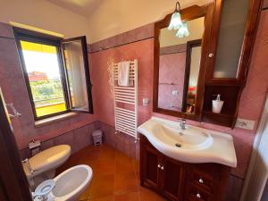 a bathroom with a sink and a toilet and a mirror at Residenza Sole e Luna Capo Vaticano in Ricadi