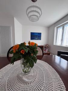 a vase with orange flowers sitting on a table at ApparTea in Marostica