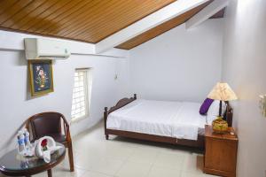 a bedroom with a bed and a table at Maison Vy Homestay in Hue