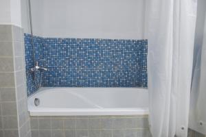 a bath tub in a bathroom with a blue tile wall at Maison Vy Homestay in Hue +53 photos