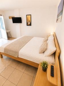 a bedroom with a bed and a table with a remote control at Flogita 5 Seaside Apartments - 150m from Beach, Ideal for Families & Groups in Flogita