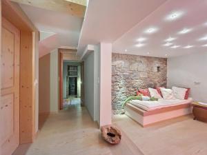 a living room with a couch and a stone wall at Haus Farbenklang in Zwiesel