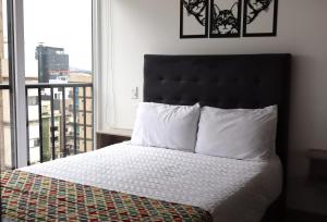 a bedroom with a bed and a window with a view at Quinta Park 43 in Bogotá