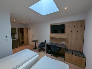 a bedroom with a bed and a desk and a tv at Hotel zur Erholung in Buxtehude