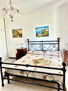 a bedroom with a bed with a black bed frame at Trilocale A2 in Marina di Bibbona +2 photos