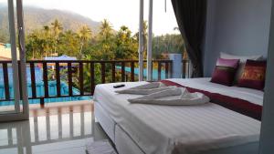 a bedroom with a bed with a view of a pool at Hotel Rung Phangan in Baan Tai