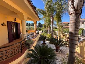 a balcony of a house with palm trees at Residenza Sole e Luna Capo Vaticano in Ricadi
