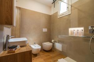 ein Badezimmer mit weißer Toilette und Waschbecken in der Unterkunft bISu in Lanusei