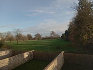 a garden with a fence and a field with trees at Parochial View in Athboy
