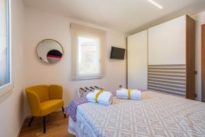 ein Schlafzimmer mit einem Bett und einem gelben Stuhl in der Unterkunft bISu in Lanusei