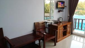 a room with a desk and a chair and a television at Hotel Rung Phangan in Baan Tai