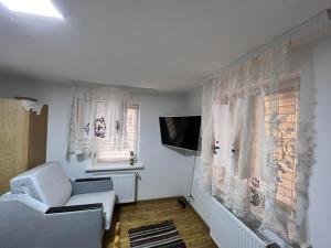 a living room with a white couch and a window at Pensiunea Beciul Vechi in Mileştii Mici