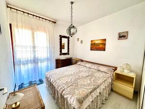 a bedroom with a bed and a large window at Trilocale A2 in Marina di Bibbona