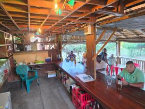 a group of people sitting at a bar in a restaurant at Lagoon Bay Chidenguele in Chidenguele