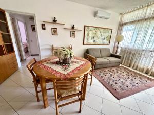 a living room with a table and a couch at Trilocale A2 in Marina di Bibbona
