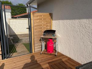 a red fire hydrant sitting on a table next to a fence at Suite indépendante avec piscine proche Océan in Saint-Vincent-de-Tyrosse