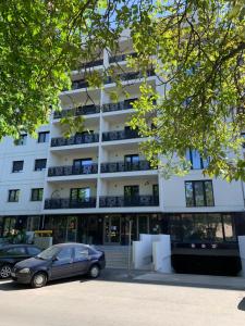 a building with a car parked in front of it at Luxury Central Monarch Residence Apartment Sleeps 5 in Timişoara