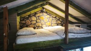 a large bed in a room with a stone wall at Stone House Montenegro in Danilovgrad