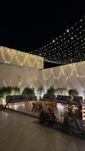a lit up patio with benches and lights at night at منتجع دار DAR Resort in Hail