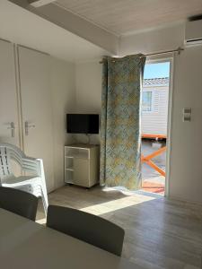a living room with a television and a room with a chair at Camping Costa Blanca in El Campello