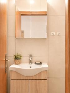 a bathroom with a white sink and a mirror at Flogita 5 Seaside Apartments - 150m from Beach, Ideal for Families & Groups in Flogita +27 photos