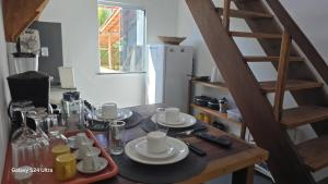 a wooden table with plates and cups and a ladder at Apartamento com Terraço na Gamboa do Morro in Cairu
