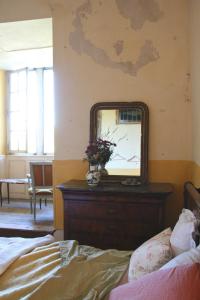 a mirror sitting on a dresser in a bedroom at Chateau Chemilly in Chemilly